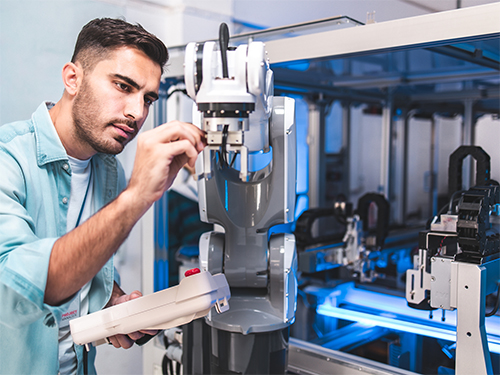 Mann stellt Roboter ein - EGS Automation