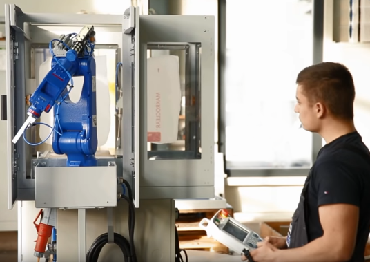 Mann stellt Roboterarm ein